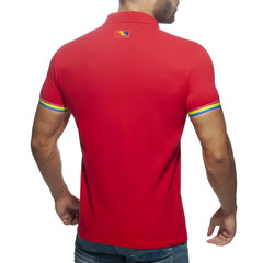 Red short-sleeved rainbow polo shirt with rainbow-striped cuffs and a small colorful logo on the collar