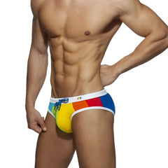 Rainbow swim brief featuring vibrant rainbow-colored fabric with white waistband and blue drawstring for swimming