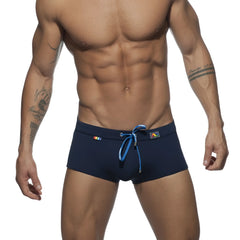 Navy blue rainbow swim trunk with bright blue drawstring and colorful logos on waistband for beachwear