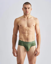 Olive green men’s reign brief made of smooth stretchy fabric with a subtle brand logo on the waistband