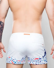White s50 seascape print swim short with vibrant colorful fish pattern hem and subtle blue dolphin on right leg