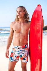 Vibrant red glossy surfboard paired with sauvage laguna boardwalk white floral swim shorts size m