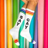 White crew socks with black say gay lettering and rainbow striped cuffs toe caps and heels for pride support