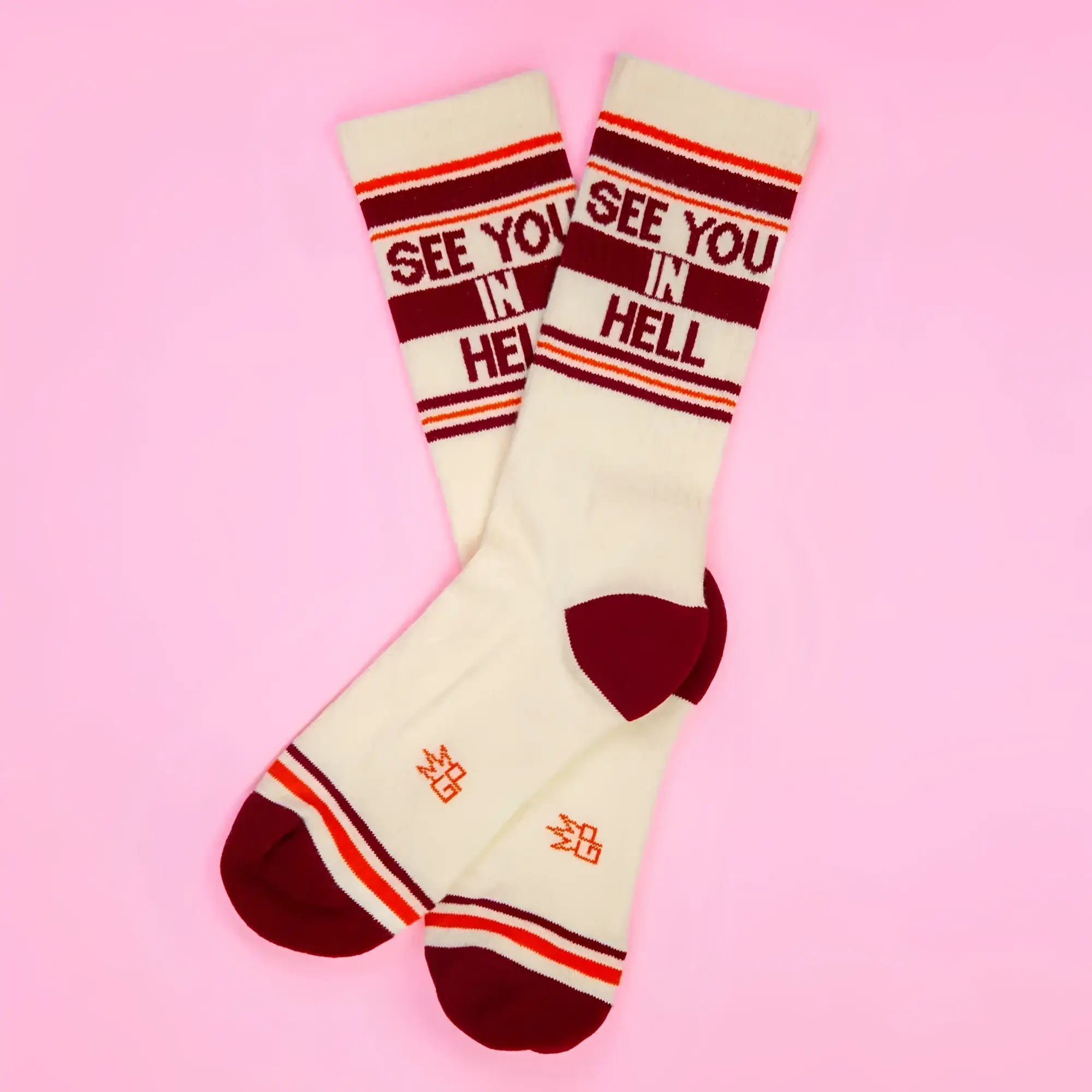 Cream-colored SEE YOU IN HELL crew socks with maroon and orange stripes and bold red lettering on cuff