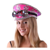 A vibrant pink steampunk festival hat with silver embellishments and ornate goggles mounted on the front