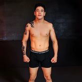 Black briefs with a white striped waistband featuring the she logo from the sheath 4.0 best-seller dual pouch boxer briefs 3-pack