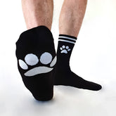 Black Sk8erboy puppy socks size 39-42 with white paw prints featuring larger and smaller designs on foot and ankle