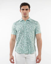 A man wearing a light green and white squares print open knit short-sleeve polo shirt