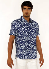 A navy blue squiggly print open knit short-sleeved button-up shirt with a white abstract pattern