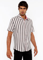 A man wearing a zigzag stripe open stretch knit shirt with white gray and black geometric vertical stripes