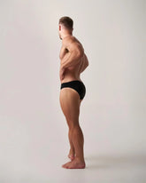Black statement swim brief made of lightweight fabric showing the front view