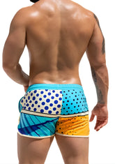 Vibrant super dog swim short featuring patchwork swim trunks in turquoise white blue polka dots and yellow orange hues