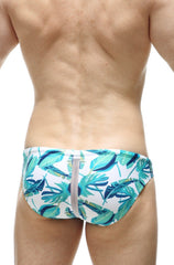 White PetitQ swim bikini Tarcu Macouba trunks with vibrant teal and green tropical leaf pattern and central gray zipper