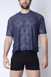 Man wearing Timoteo midnight blue lace cropped tee and black shorts against a white background.