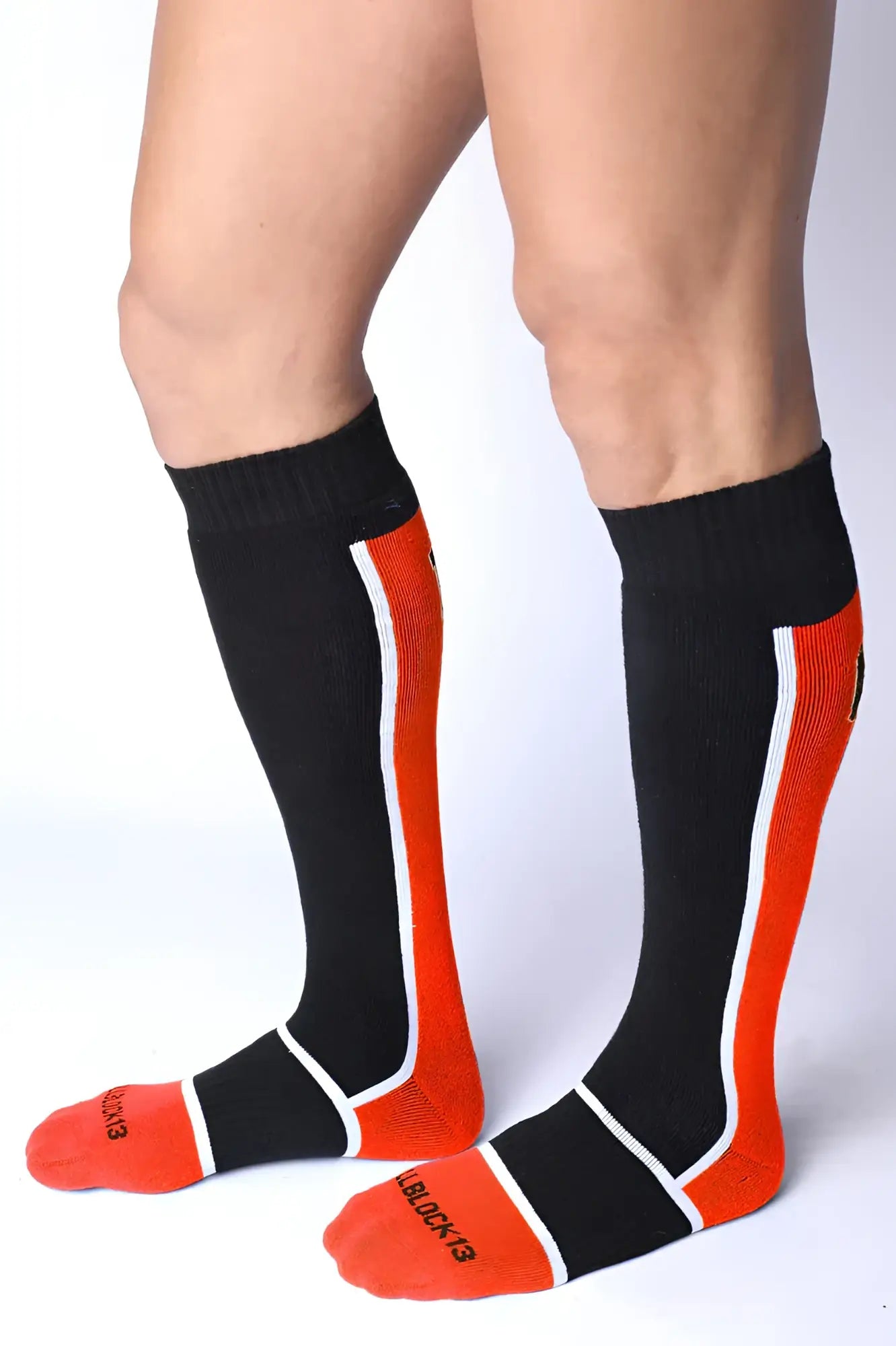 Take down knee high socks in black and orange with white trim ribbed texture and black & red branding on the foot