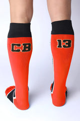 Take down knee high sock bright orange athletic socks with black ribbed cuffs toe accents and bold cb 13 lettering
