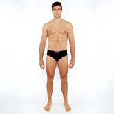 Black textured swim brief with front buckle and silver metallic x shaped logo on the waistband