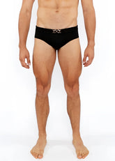 Black textured swim brief with a silver metallic interlocking double-x front buckle belt for stylish beachwear