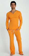 A man wearing a thermal v-neck long sleeve sun orange top and matching pants with white drawstrings