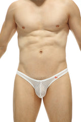 Man wearing white mesh thong with small red logo on the waistband, standing against white background.