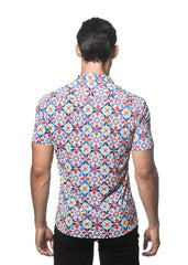 A man wearing a tile printed performance short-sleeved shirt with contrast placket in red blue and cream tones