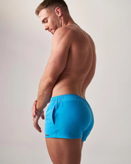 Bright blue statement swim short with elastic waistband and side pockets for athletic and casual use
