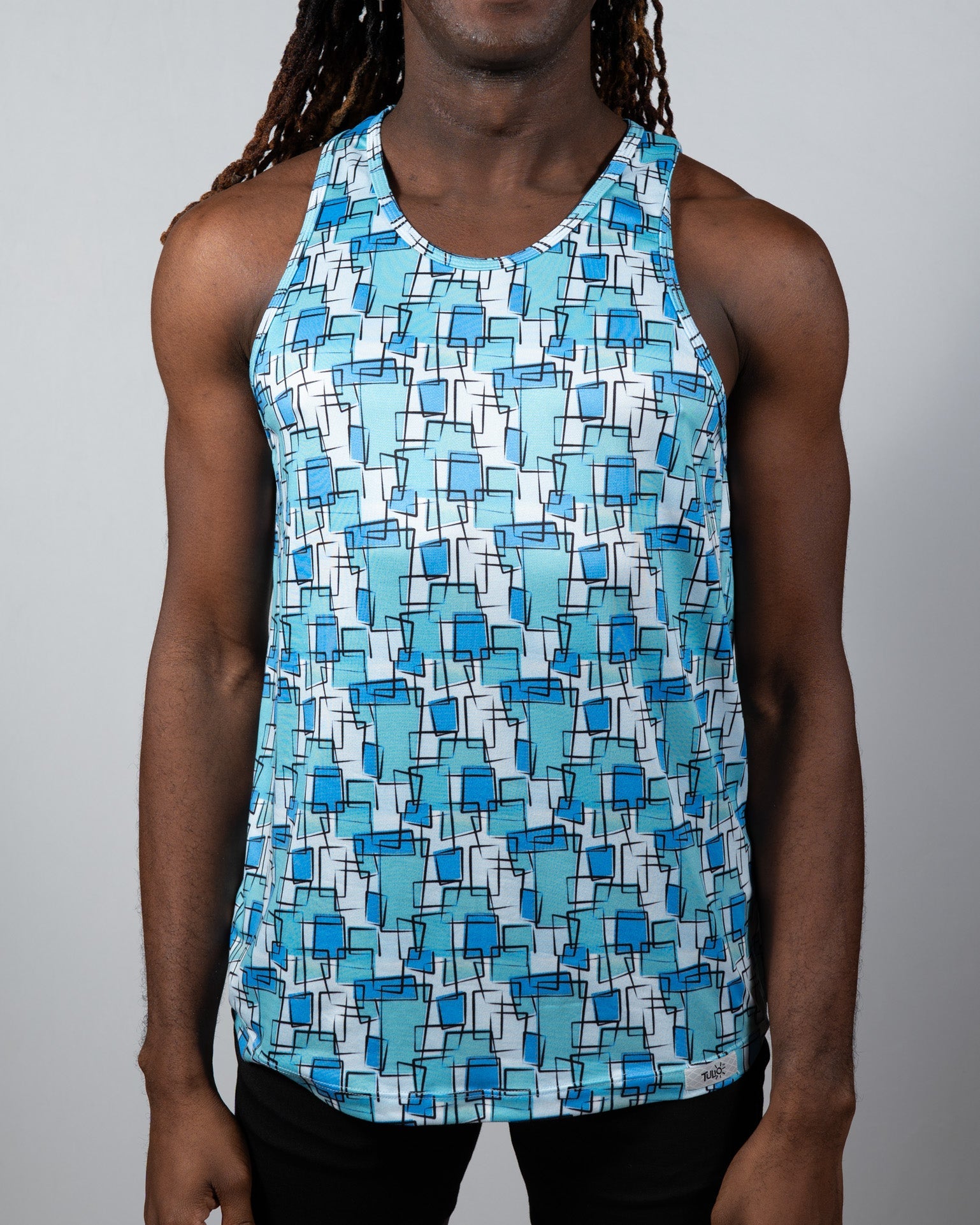 A men’s wallpaper print tank with a vibrant blue geometric pattern of squares and rectangles on a white background