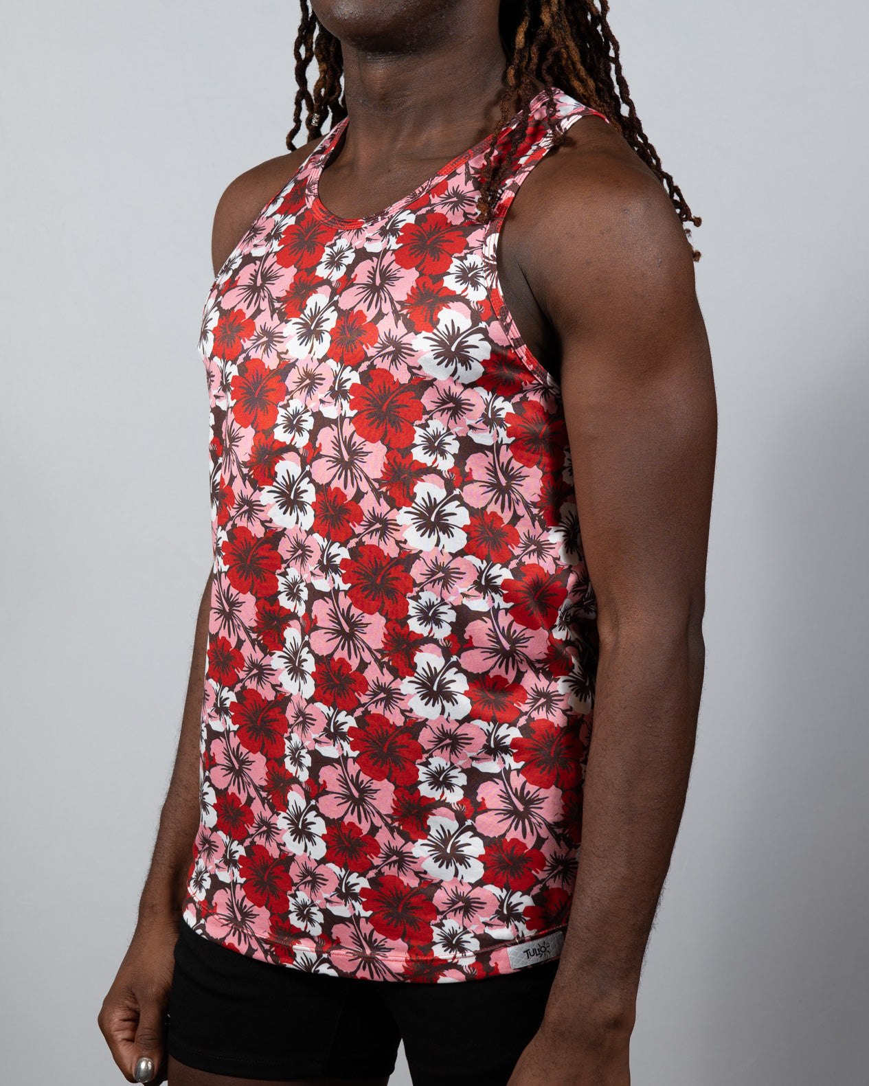 A vibrant red pink and white Hawaiian hibiscus print tank top with racerback design made of lightweight fabric