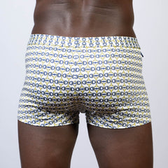 White designer buckle print square cut swim trunks with navy blue and yellow interlocking d-shape patterns