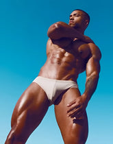A man wearing white form-fitting briefs v10 core bikini highlighting comfortable stretch fabric and sleek design