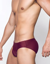 V10 core bikini maroon swim trunks with subtle logo on waistband shown from the back side