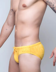 Bright yellow v10 ripple textured swim brief with subtle abstract pattern and orange drawstring for swimming