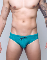 Teal v10 ripple textured swim brief with subtle wave pattern and matching drawstring tie for swimming use