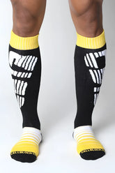 Black velocity 2.0 knee high socks with bold white graphic and bright yellow ribbed cuffs toe caps and heel accents