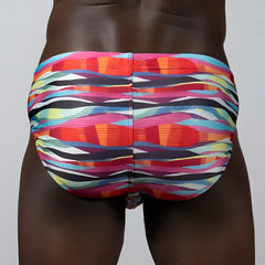Vibrant waves print brief swim trunks with bold abstract stripes in pink orange blue and black for beachwear