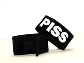 Black wristband cock ring by wildmant featuring bold white embroidered piss lettering for fetish use