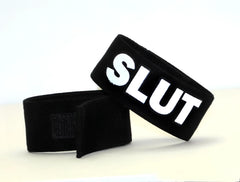 Black velour wristband with bold white embroidered slut lettering and velcro closure from wildmant fetish max cock ring slut