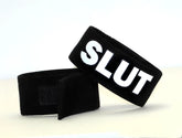 Black velour wristband with bold white embroidered slut lettering and velcro closure by wildmant fetish max cock-ring-slut