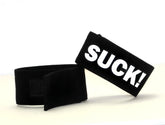 Black velour wristband with bold white suck lettering from wildmant fetish max cock ring suck collection