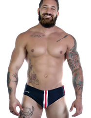 WildmanT sportivo bikini black with red stripe navy blue swim trunks with red and white side stripes and logo near waistband