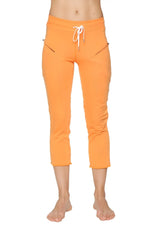Women’s sun orange capri yoga pant with white drawstring waistband and side zipper pockets in 4/5 length