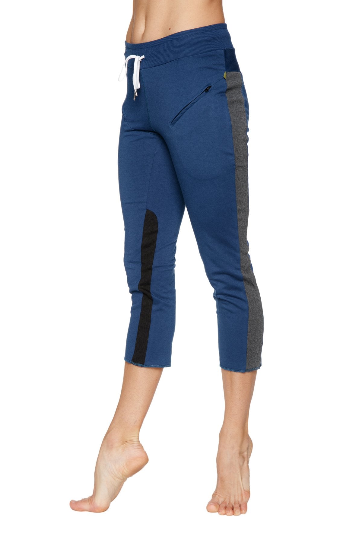 Women’s royal blue capri yoga pants with gray and black side panels, white drawstring, and zippered thigh pocket