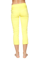 Bright yellow women’s 4/5 length capri yoga pants with smooth stretchy fabric and subtle side slits