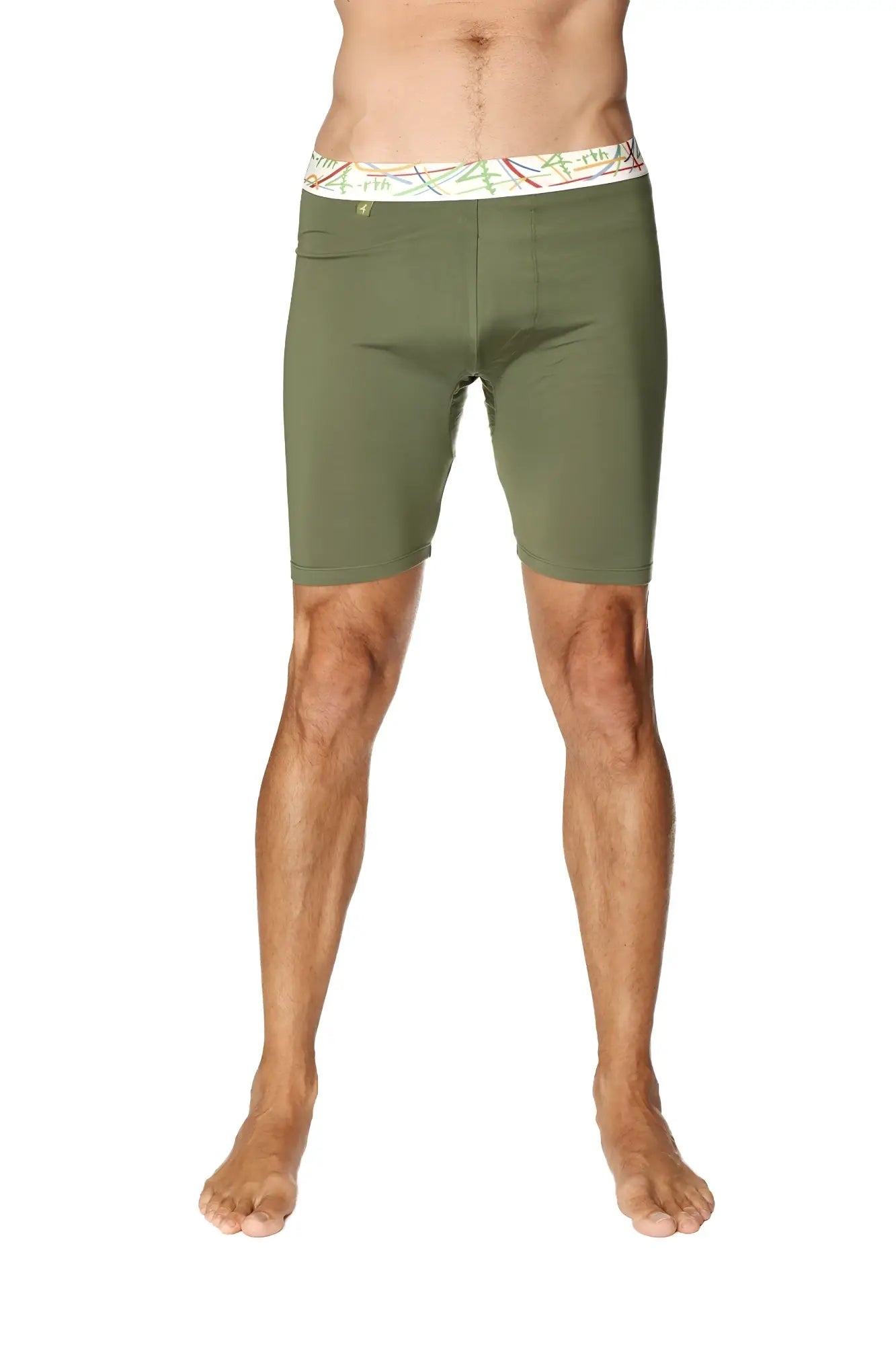 Olive green yoga compression shorts with white waistband featuring colorful abstract patterns in rainforest green