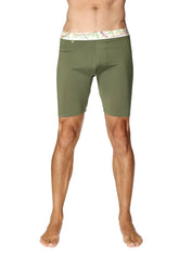 Olive green yoga compression shorts with white waistband featuring colorful abstract patterns in rainforest green