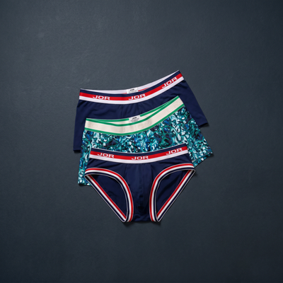 Designer mens briefs and trunks flat lay on charcoal slate — Featured Clearance sale styles from top brands