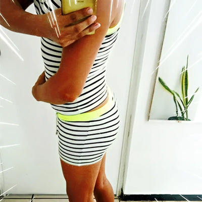 Side view of a person wearing a striped tank top and shorts set.