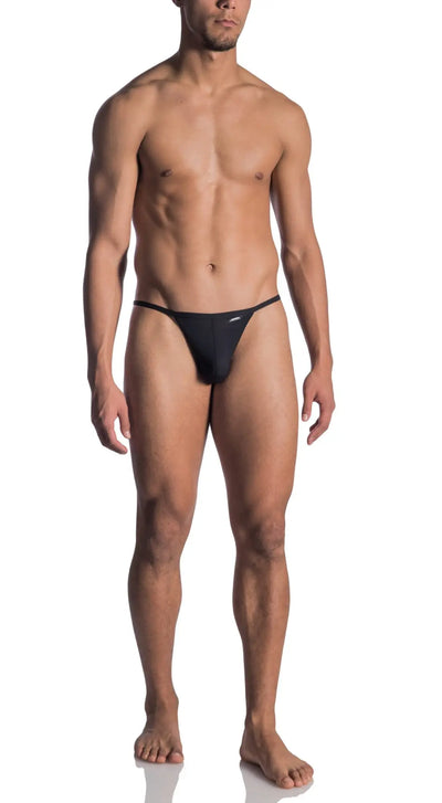 Muscular man wears a black thin-strap thong against a white background.