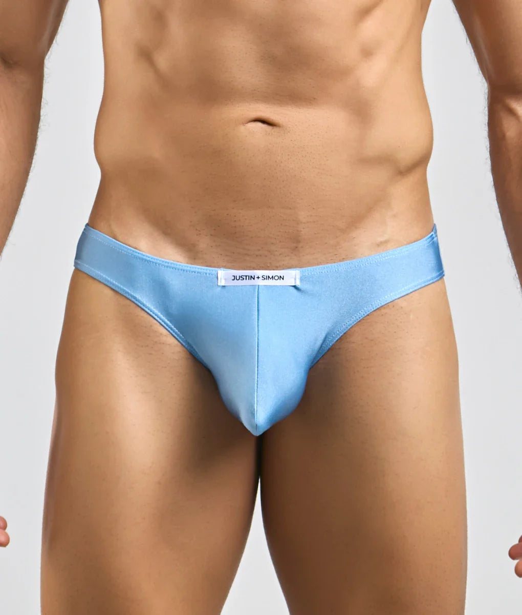 Light blue Justin + Simon classic mens bikini briefs with sleek form-fitting design and subtle brand tag at waistband