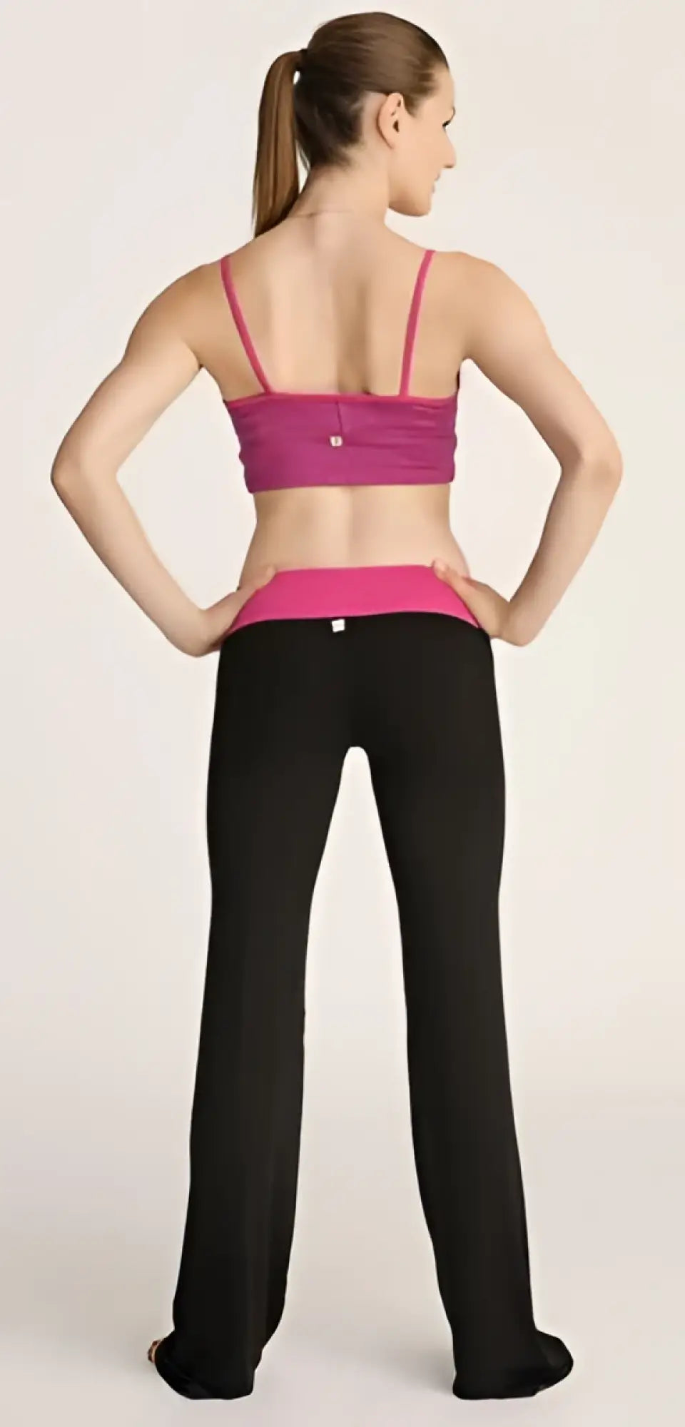 A vibrant magenta sports bra with thin straps and matching waistband paired with sleek black 4-rth classic yoga pants